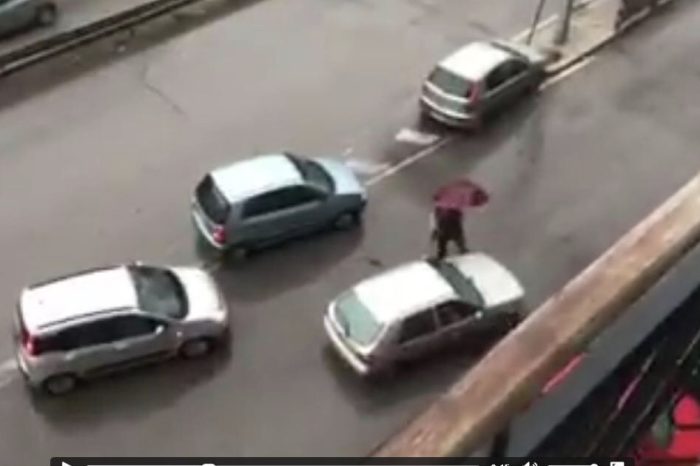Taranto - Cittadino dirige il traffico sotto la pioggia. | VIDEO