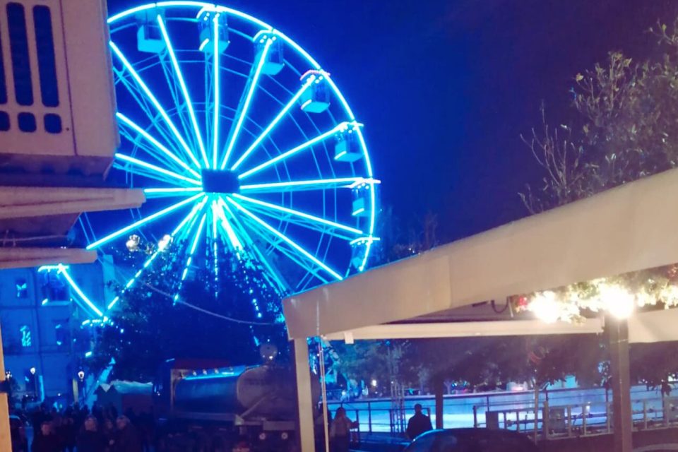 La ruota panoramica illumina la serata, ma non riesce a rischiarare i dubbi sollevati dall'annullamento dell'inaugurazione della pista di pattinaggio.