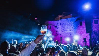 Foto panoramica serale del centro storico di Vieste durante l’evento, con persone che degustano vino rosato