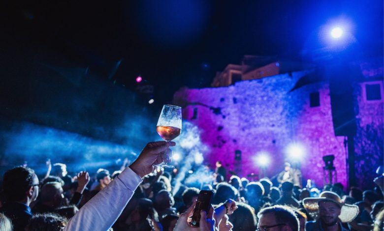 Foto panoramica serale del centro storico di Vieste durante l’evento, con persone che degustano vino rosato