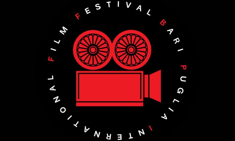 Fotografia di una scrivania con fogli di sceneggiatura, una penna, e un laptop acceso su un software di scrittura